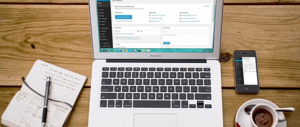 Computer med kaffe og notesblog ved siden